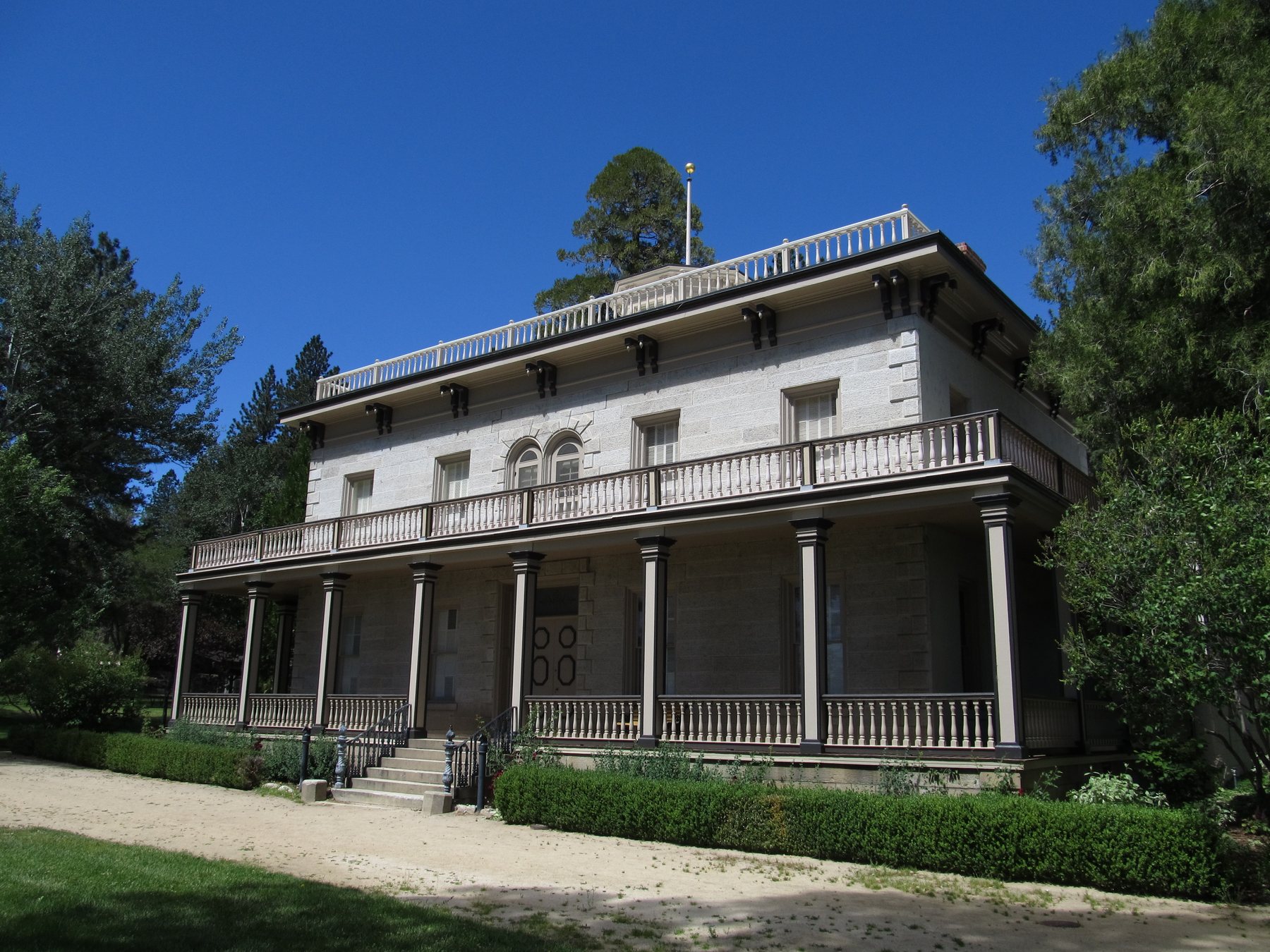 Side view of Bowers Mansion with arched porch details and surrounding trees.