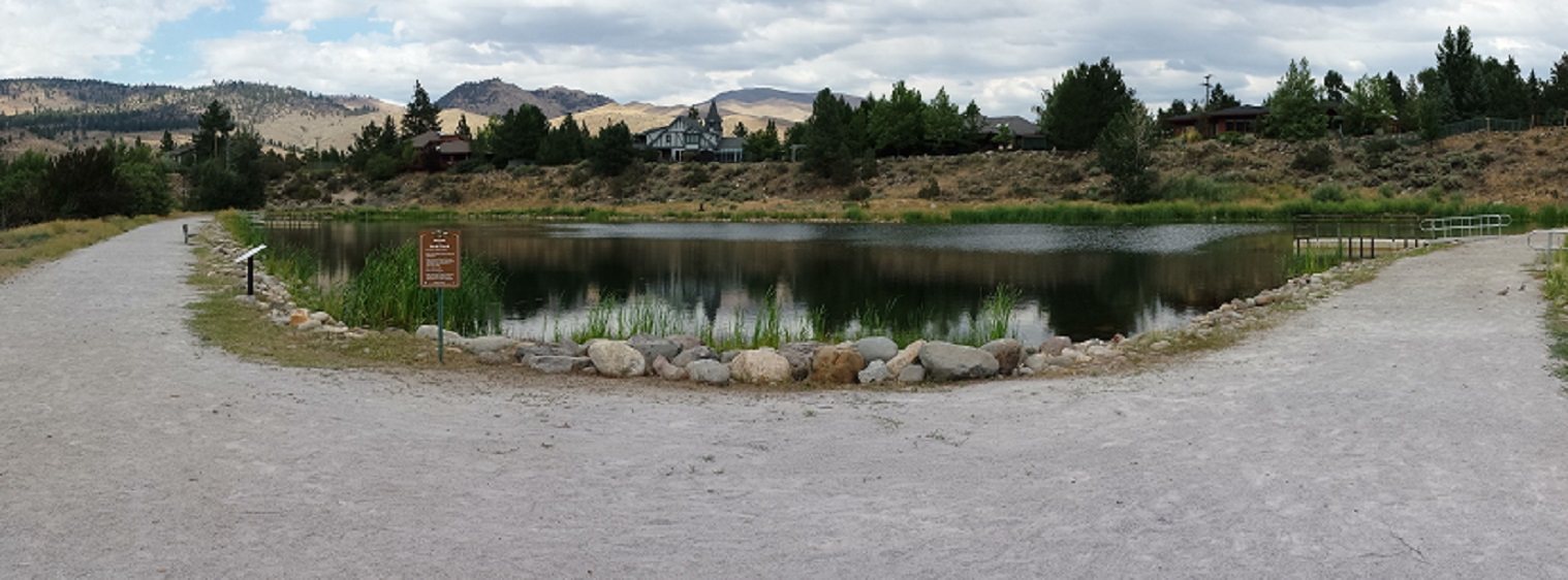 Crystal Peak Park pond bordered by trees and reflections near Verdi.