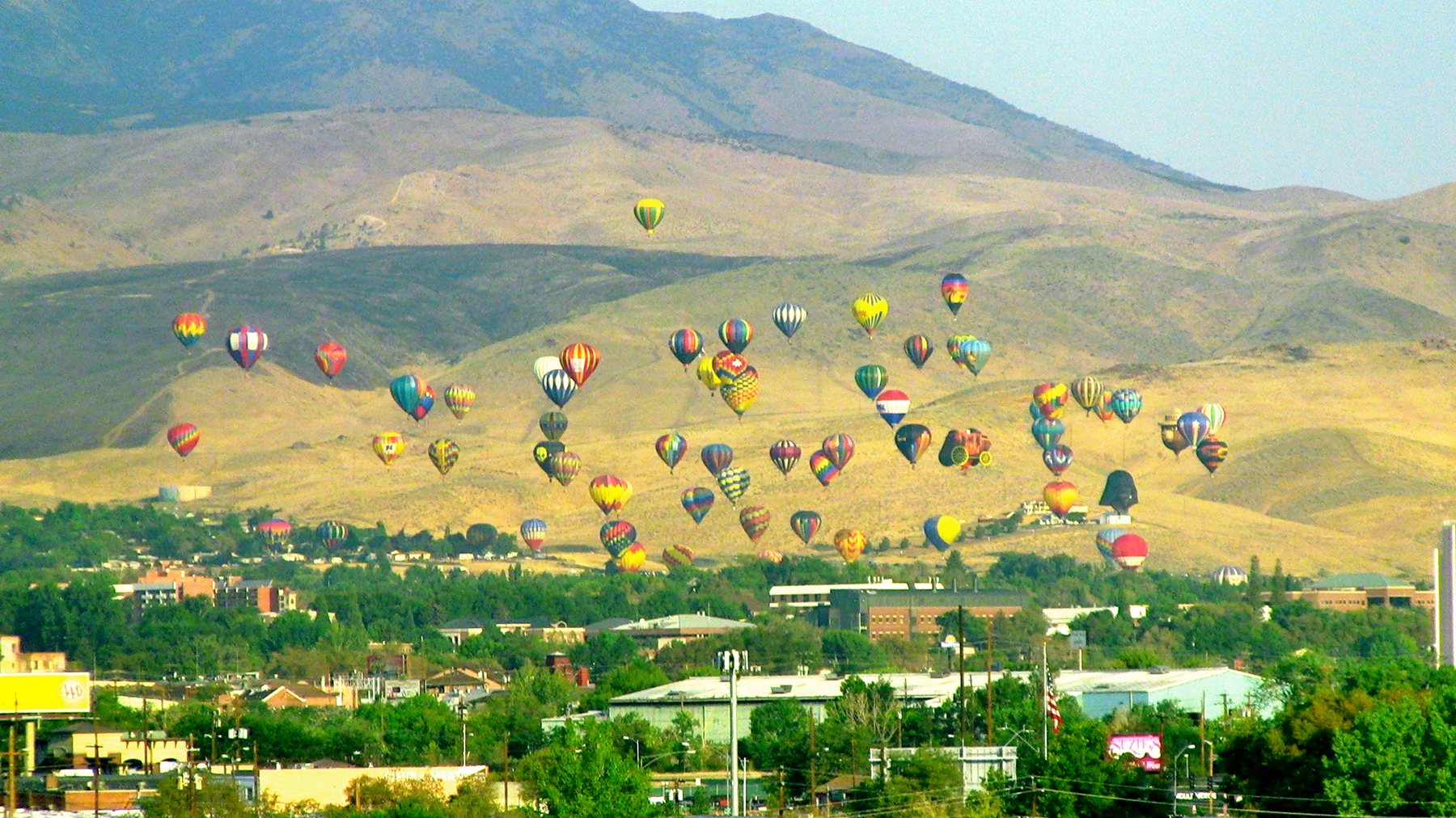 Hot air balloons lifting into the early morning sky during The Great Reno Balloon Race.