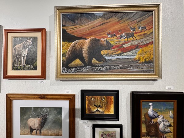 image of several landscape paintings displayed on a white wall